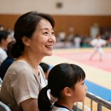 学员家长王女士头像照片，一位约40岁的女性，穿着简约，在观众区微笑着看孩子训练。